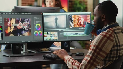 Poster - African american employee editing video content on multimedia software, using focus lighting and color grading. Male filmmaker working on movie montage edit on pc multi monitors.