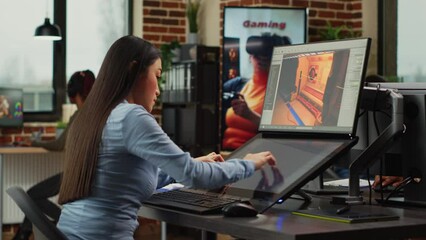 Poster - Asian game developer working in production department to create professional content, using touchscreen display. Expert developing 3D scenes and graphics on professional software.