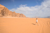 Fototapeta  - kobieta idąca po pustyni