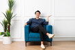 © 1112000 - portrait of asian man sitting on sofa at home