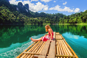 Beautiful young girl discovering the wonders of Ratchaprapa by bamboo raft (Thailand)