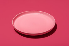 Pink plate isolated on a vibrant magenta background