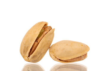 Two unpeeled pistachios, close-up, isolated on white.