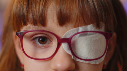 close-up portrait of sick ill girl face looking at camera, having protective bandage plaster patch s
