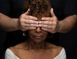 Elderly old 70+ year old black African American woman being oppressed by white Caucasian man holding his hands over her eyes so she is blind and can't see the truth of racism