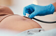 © T Mdlungu/peopleimages.com - Hand, stethoscope and the belly of a woman pregnant in a hospital for prenatal exam or checkup in the hospital. Healthcare, medical and pregancy with a doctor listening to the baby of a mother to be