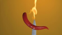 Hot Red Chili Pepper On A Knife In Flames Burn