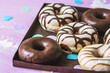 Chocolate Donuts, Berliner, Krapfen on a rusty tray on pink background