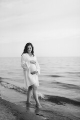 Wall Mural - pregnant girl with brown hair on the seashore