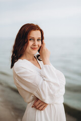 Wall Mural - pregnant girl with brown hair on the seashore