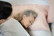 Nurse support supporting senior woman on bed in bedroom at nursing home,Senior services and geriatric care concept.