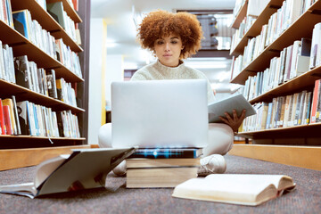 Poster - College library learning, laptop and black woman student working on the floor with books. Reading, computer research and online study of a person with test and exam information for university