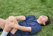 © ADDICTIVE STOCK - Upset boy lying on grass after injury