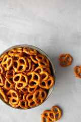 Wall Mural - Mini Pretzels with Salt in a Bowl on a gray surface, top view. Flat lay, overhead, from above. Copy space.