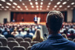 © Antoine - Symposium sur les affaires et l'entrepreneuriat. Conférencier donnant une conférence lors d'une réunion d'affaires. Public dans la salle de conférence. Micro. Vue arrière d'un participant (AI)