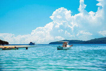 Wall Mural - beautiful scenic landscape with a boat in the bay and a wooden pier near nydri, lefkada, greece