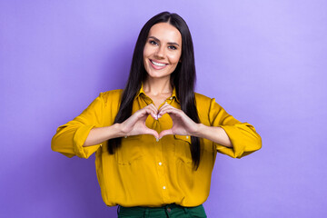 Sticker - Photo of lovely positive girl toothy smile arms fingers demonstrate heart symbol isolated on violet color background