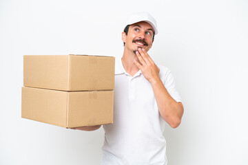 Wall Mural - Delivery caucasian man isolated on white background looking up while smiling