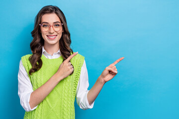 Wall Mural - Photo portrait of attractive young woman eyewear point empty space shopping banner wear trendy green look isolated on blue color background