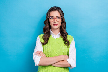 Poster - Photo portrait of lovely young lady specs folded arms confident freelancer dressed stylish green outfit isolated on blue color background