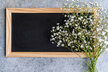 Overhead View Of A Bunch Of White Gypsophila Flowers On A Blank Blackboard
