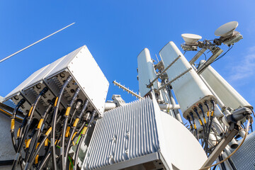 Close-up of a tower with a 5G and 4G cellular network antenna against a blue sky
