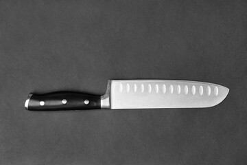 Large kitchen knife on a black background top view