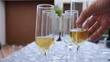 varias copas llenas de champan y mano de una persona cogiendo una de ellas, perfecto para una celebracion o fiesta
