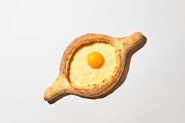 Adjarian khachapuri on white background. Traditional dish of Georgian cuisine, dough boat with cheese and egg yolk