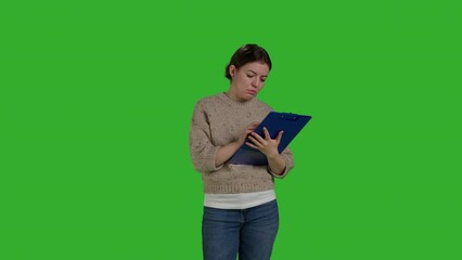 Poster - Front view of female model looking at clipboard documents, working on analysis and taking notes on papers. Young adult writing information on files, greenscreen backdrop in studio.