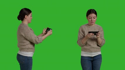 Poster - Young cheerful adult playing videogames online on mobile phone, using smartphone to have fun with gaming competition on internet app. Woman enjoying play on telephone, greenscreen studio.
