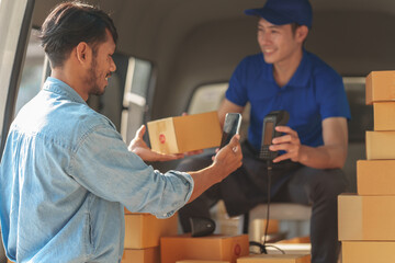 Delivery man asia people checking portable delivery device with parcel box to customer home address. Using mobile scan qr code on EDC machine.