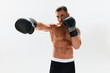 © SHOTPRIME STUDIO - Man athletic bodybuilder poses in boxing gloves with nude torso abs in full-length background, boxing and martial arts. Advertising, sports, active lifestyle, light, competition, challenge concept.