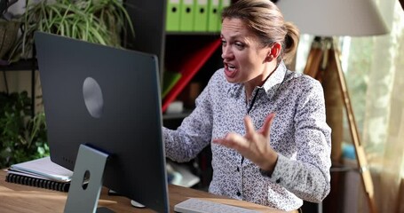 Portrait of upset woman looking at computer screen and screaming