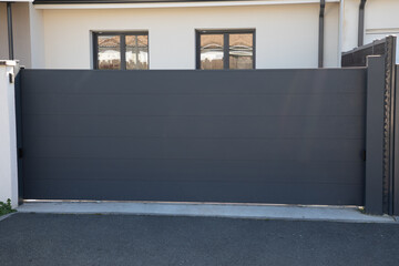 Wall Mural - door grey slide steel gate aluminum portal of home suburbs house in street view