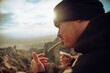 © Cavan Images - Boy smoking a marijuana joint on top of a mountain during sunset