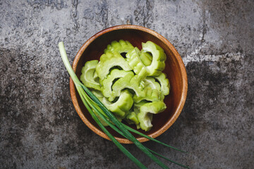 Wall Mural - Fresh bitter melon slices- Bitter melon slice in wooden bowl