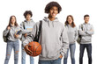 © Ljupco Smokovski - Male african american student holding a basketball and other students posing in the back