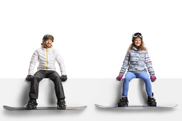 Sticker - Young man and woman with snowboards sitting on a blank panel