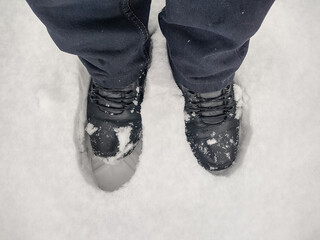 Poster - A man stands with his boots on in the deep snow