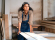 Portrait, female multiracial carpenter working in woodshop small business. Afro woman with goggles standing in DIY carpentry workshop with confidence. Empowerment joiner women in woodworking industry
