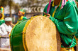 Detalhe de um folião vestido de verde, tocando bumbo durante as Congadas, festa religiosa típica brasileira.
