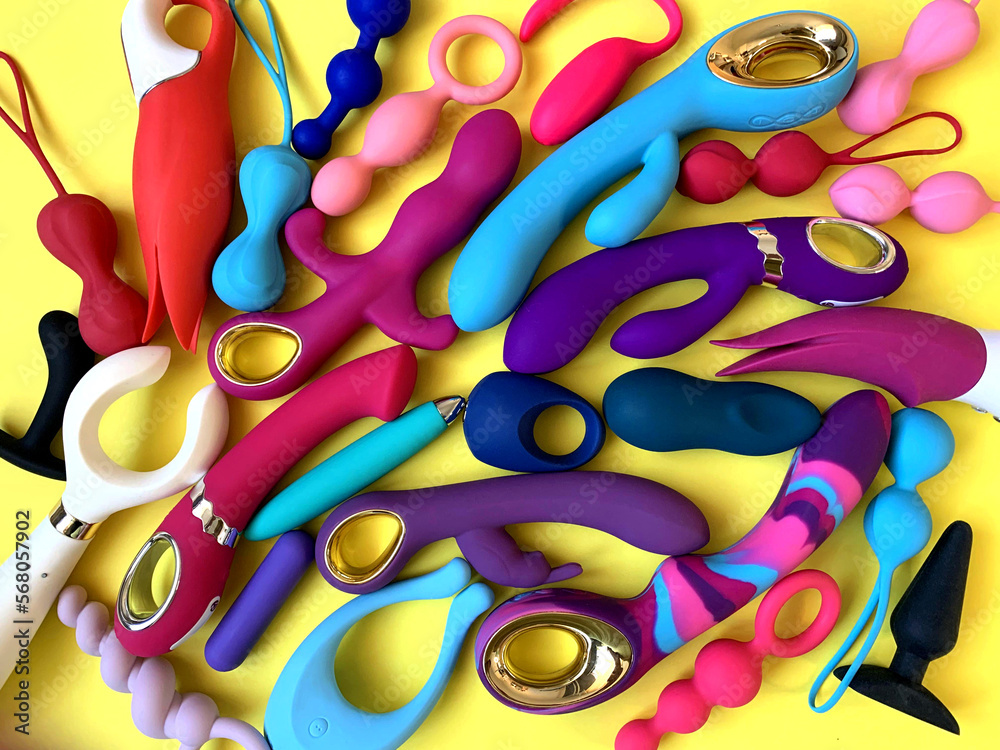oral sex lubricants Many sex toys. Vibrators, butt plugs, jiggle balls, cock rings. Sex shop  assortment on yellow background. Flat lay Stock Photo