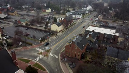 Wall Mural - A drone captures footage of a pull-back shot above the settlement of Bardstown, Kentucky, showcasing the roundabout surrounding the historic Nichols County Courthouse with limited traffic.