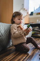 Wall Mural - small caucasian girl toddler child play with finger puppets at home