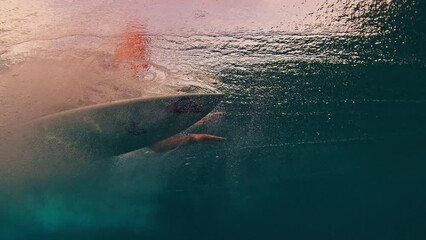 Sticker - Surfer underwater. Man dives under the wave with surfboard to pass the wave, speed warped version of the footage. Underwater view of the surfer duck diving under the wave