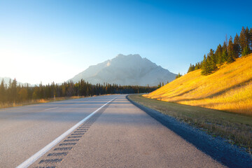 Wall Mural - view of the road during sunset. high mountains on the horizon. bright sun during sunset. direction o