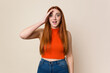 © Asier - Young red hair woman isolated shouts loud, keeps eyes opened and hands tense.