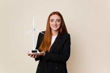 Young business woman holding a windmill, clean energy concept