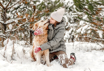 Wall Mural - Golden retriever dog with girl in winter time